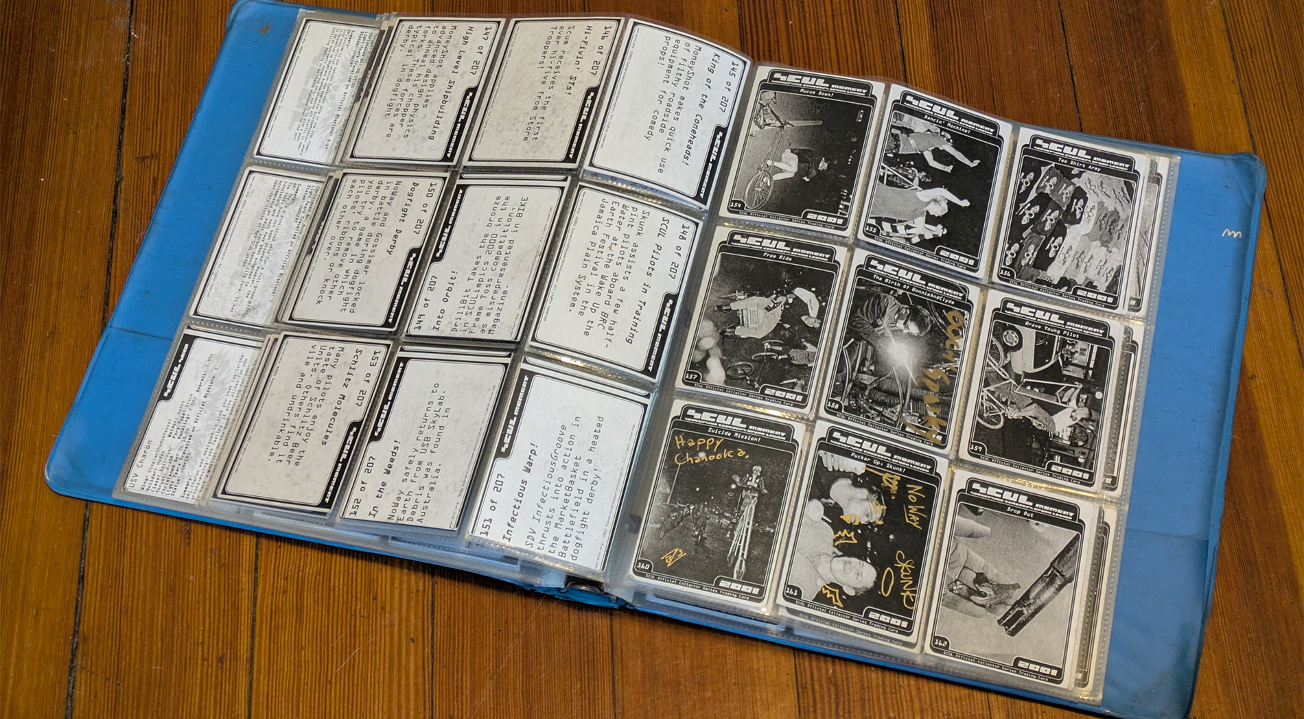 an old blue vinyl three ring binder holding plastic sleeves of worn down black and white trading cards