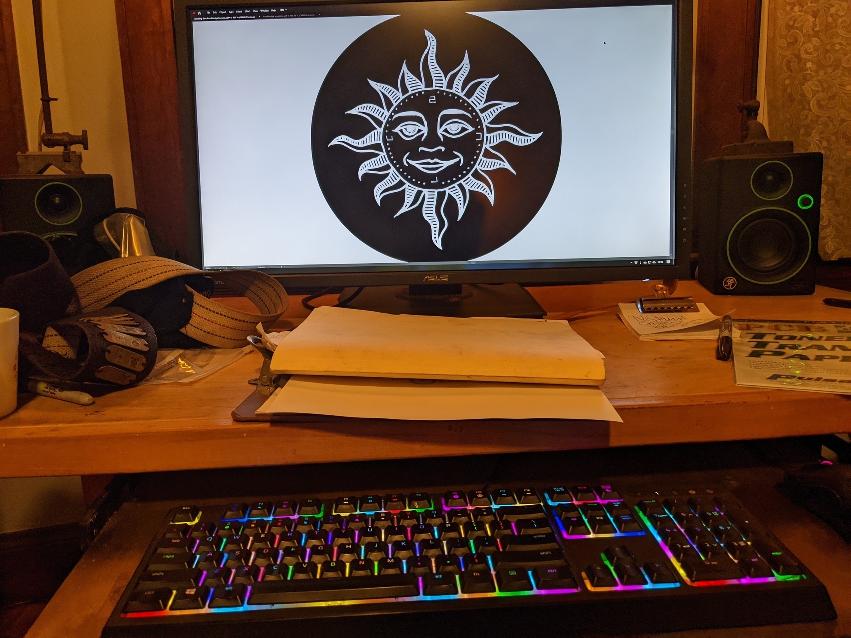 a computer screen showing a design for a headbadge — a sleepy faced sun with serpentine rays and cardinal points labeled S C U L