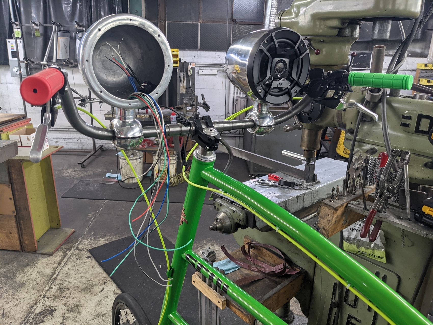 a tallbike frame with a lot of wires and electronics inside, and a computer screen showing the wiring diagram